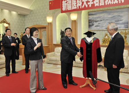 李党委员书记（右二）介绍该校致赠池田会长的博士袍