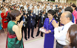 Los esposos Ikeda obsequian un broche de flores a una miembro participante de la India (6 de febrero de 2008)