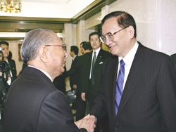 El consejero Tang (derecha) es recibido por el presidente Ikeda