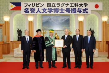 El presidente Wagan (tercero desde la izquierda) entrega el certificado al presidente Yamamoto (tercero desde la derecha).