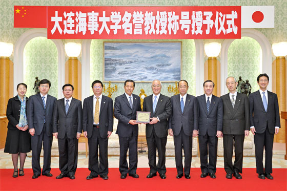 Vicepresidente Wang (5º de la izquierda) entrega el título al representante del señor Ikeda, Hideo Yamamoto, presidente de la Universidad Soka