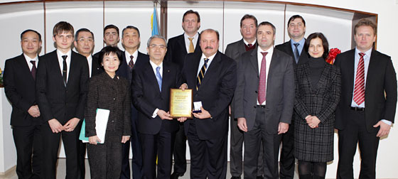 El embajador Kulinich (der.) y el presidente Harada sostienen la placa honorífica