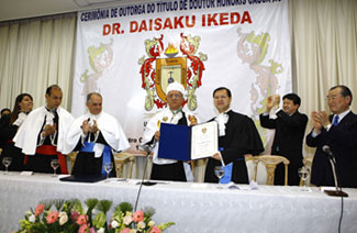 El rector de Uni-Anhangüera (cuarto desde la izquierda) entrega el diploma a Hiromasa Ikeda, hijo del destinatario (tercero desde la derecha)