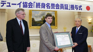 De izquierda a derecha: El ex presidente Larry Hickman y el presidente Jim Garrison de la Sociedad John Dewey entregan diploma a Daisaku Ikeda